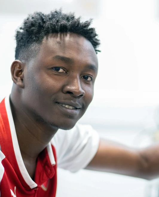 Close-up of a student in a red football jersey adjusting an oscilloscope, displaying a waveform on the screen. Close-up of a student in a red football jersey adjusting an oscilloscope, displaying a waveform on the screen.